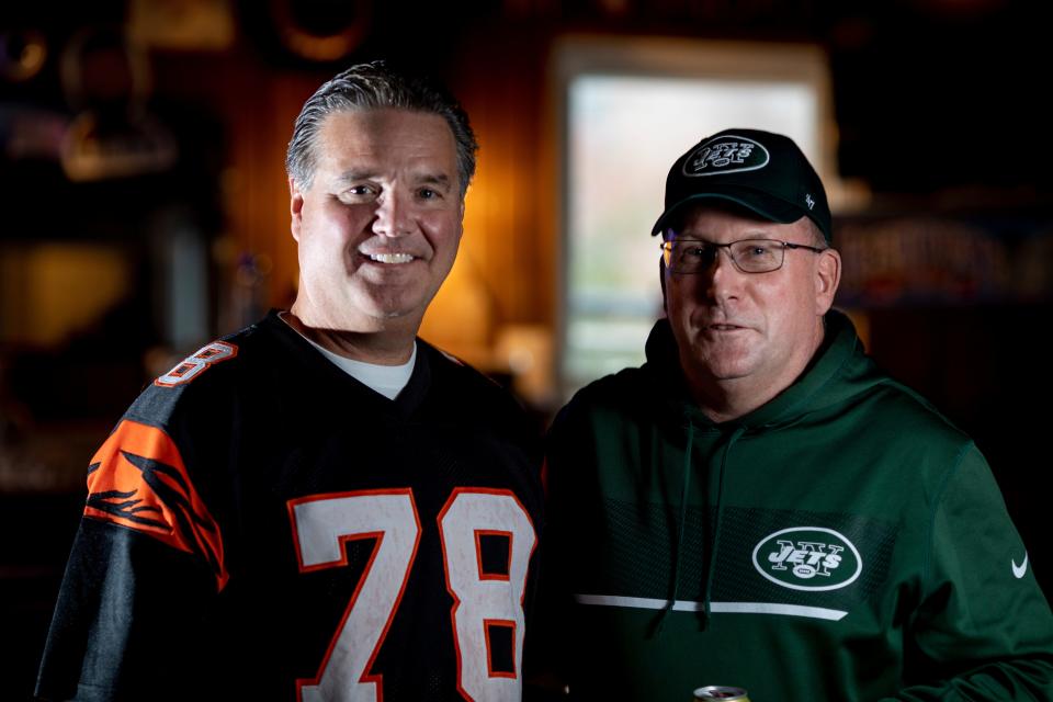 Jeff Wagner, left, Bengals fan, and Joe Carolin, Jets fan, stand together inside Dana Garden on Saturday, Oct. 30, 2021. 