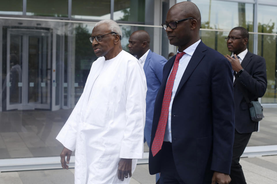 Former president of the IAAF (International Association of Athletics Federations) Lamine Diack, left, arrives at the Paris courthouse, Wednesday, June 10, 2020. A sweeping sports corruption trial opened Monday in Paris involving allegations of a massive doping cover-up that reached to the top of world track and field's governing body. Lamine Diack, 87, who served as president of the body for nearly 16 years, is among those accused of receiving money from Russian athletes to hide their suspected doping so they could compete at the Olympics in 2012 and other competitions. (AP Photo/Thibault Camus)