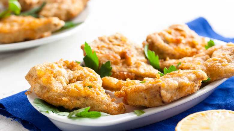 deep fried artichoke hearts, halved on a white plate