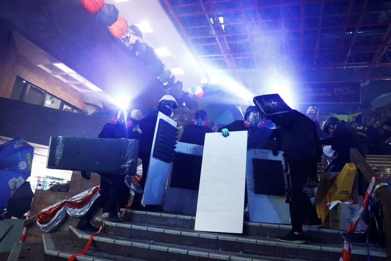 Anti-government protesters retreat back into the campus during the clashes with the police outside the Polytechnic University in Hong Kong