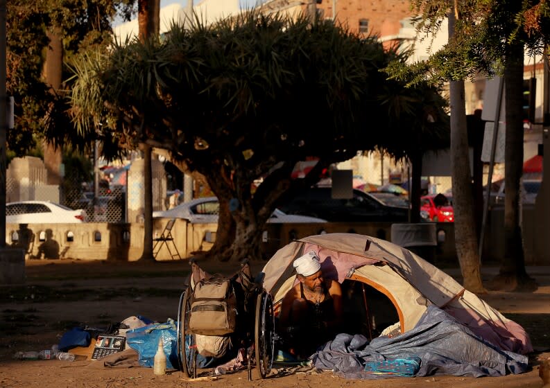 LOS ANGELES, CALIF. - OCT. 15, 2021. A homeless man named John sorts through his belongings before leaving MacArthur Park in Los Angeles on Friday, Oct. 15, 2021. He said he had been living at the park for about a year. Officials gave the homeless until 10:30 p.m. on Friday to leave the park, which will be closed for an extensive cleanup and renovation project. (Luis Sinco / Los Angeles Times)