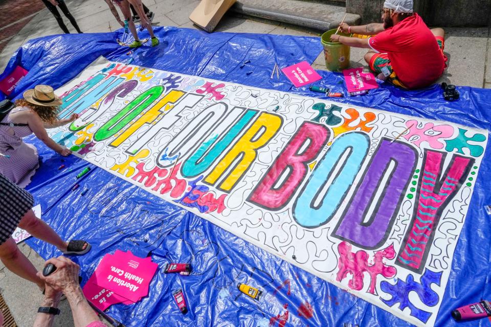 Abortion-rights activists finish a banner in front of the Rhode Island Supreme Court building on South Main Street during a recent rally.