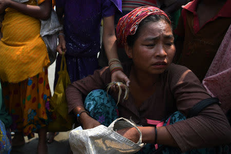 A Chakma woman sits on Shamlapur beach with buckets of tamarind to exchange for fish, in Cox's Bazaar, Bangladesh, March 24, 2018. REUTERS/Clodagh Kilcoyne