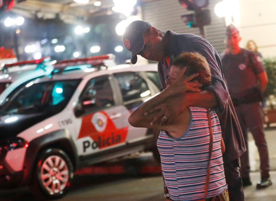 <p>Police officer comforts a woman near the site where a building collapsed in downtown Sao Paulo, Brazil May 1, 2018. (Photo: Leonardo Benassatto/Reuters) </p>