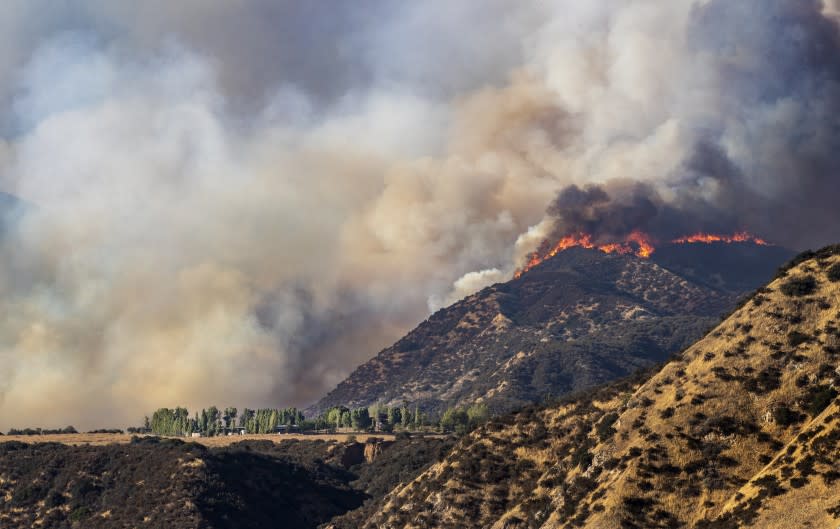 CHERRY VALLEY, CA - AUGUST 1, 2020: Flames shoot up along a ridge above a home as the Apple fire burns out of control during the coronavirus pandemic on August 1, 2020 in Cherry Valley, California. (Gina Ferazzi / Los Angeles Times)