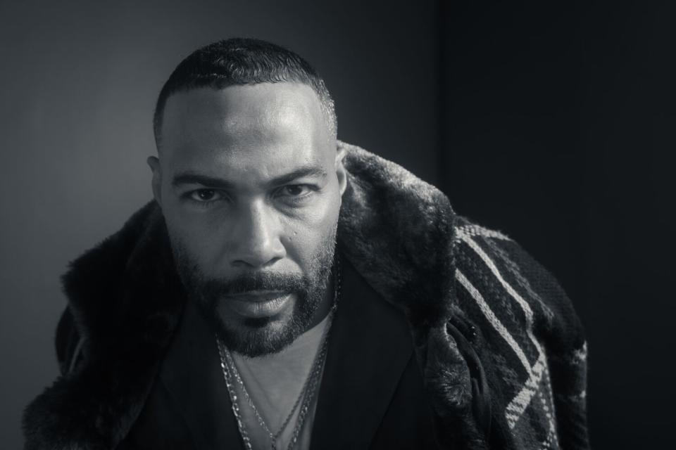 Omari Hardwick looks serious while wearing a coat.