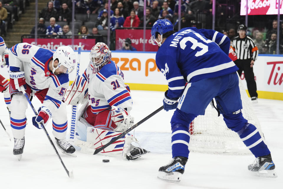 New York Rangers goaltender Igor Shesterkin (31) makes a save on Toronto Maple Leafs forward Auston Matthews (34) as defenseman Erik Gustafsson (56) defends during the second period of an NHL hockey game Tuesday, Dec. 19, 2023, in Toronto. (Nathan Denette/The Canadian Press via AP)