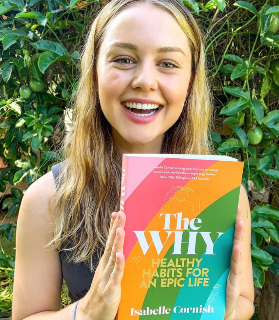 Isabelle Cornish smiles while holding her book, The Why. Photo: Instagram/isabellecornish.
