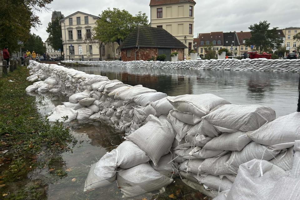 Stacked sandbags lie near the old town during heavy storm in Wismar at the Baltic Sea, Germany, Friday, Oct. 20, 2023. (AP Photo/Matthias Schrader)