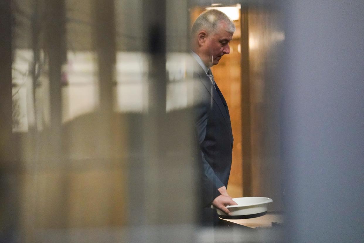 Former Ohio House Speaker Larry Householder waits to retrieve his personal items after going through security at Potter Stewart U.S. Courthouse in Cincinnati.