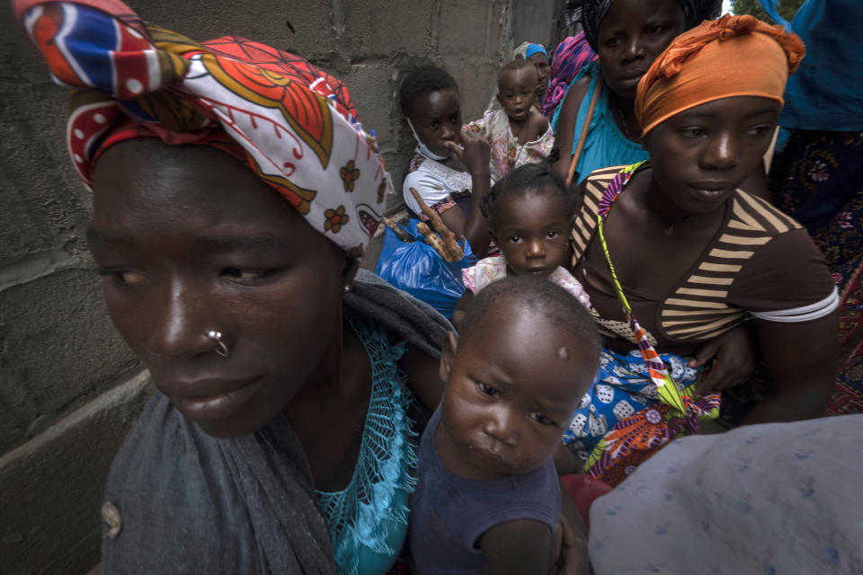 Displaced women with their children wait for assistance at a building used by refugees as shelter in Pemba, Mozambique, after they fled attacks in Palma in Northern Mozambique, Monday April 19, 2021. The damage caused by Mozambique's extremist rebels in their deadly assault on the northeastern town of Palma continues to be assessed. More than three weeks after the rebels launched a three-pronged attack, which lasted at least five days, Mozambican police and relief agencies are working to help the thousands uprooted by the violence and restore the town to daily life.(AP Photo)