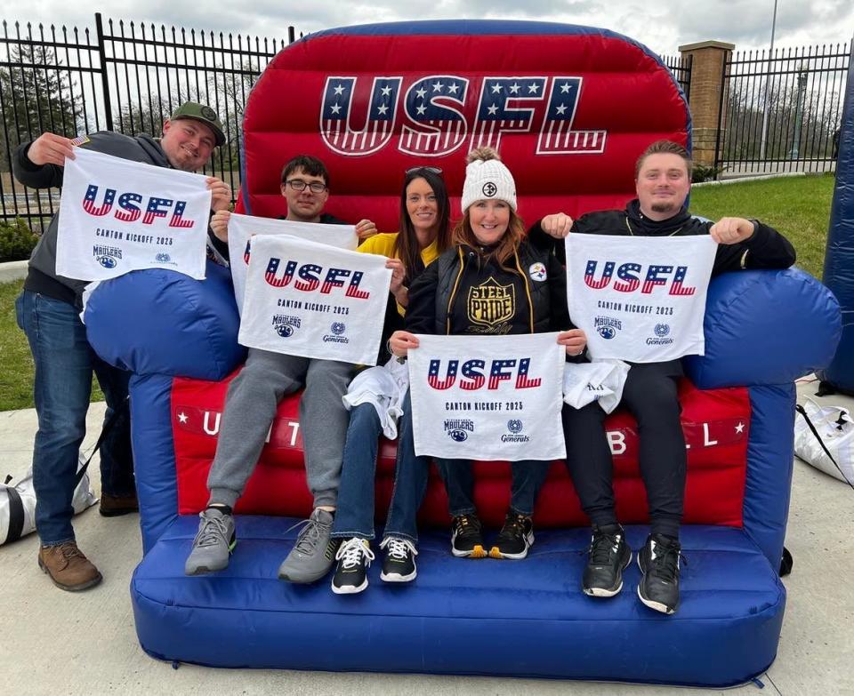 A group of USFL fans pose for a photo in a large inflatable chair at Tom Benson Hall of Fame Stadium on Sunday for the regular season opener between the New Jersey Generals and Pittsburgh Maulers.