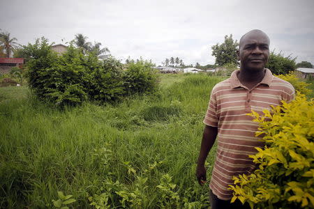 Georges Doue, 51, who lost seven members of his family in the 2011 massacre, stands in a flowered garden in the Carrefour neighbourhood where hundreds of people were buried after a massacre on March 28, 2011, an area predominantly inhabited by Gueres, an ethnic group seen as among former President Laurent Gbagbo's staunchest supporters, in Duekoue June 23, 2015. REUTERS/Luc Gnago