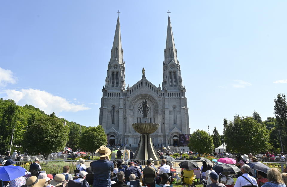 A crowd gathers outside the Basilica of Sainte-Anne de Beaupre east of Quebec City, Thursday, July 28, 2022. (Bernard Brault /The Canadian Press via AP)