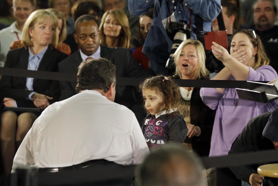 People react as three-year-old Nicole Mariano tells New Jersey Gov. Chris Christie, "my house is still broken," during a town hall meeting Thursday, Feb. 20, 2014, in Middletown, N.J. Christie called her closer and promised that someone from his administration would see about helping her mom. Then they high-fived. Christie is blaming the federal government for deficiencies in the state's Superstorm Sandy recovery. (AP Photo/Mel Evans)