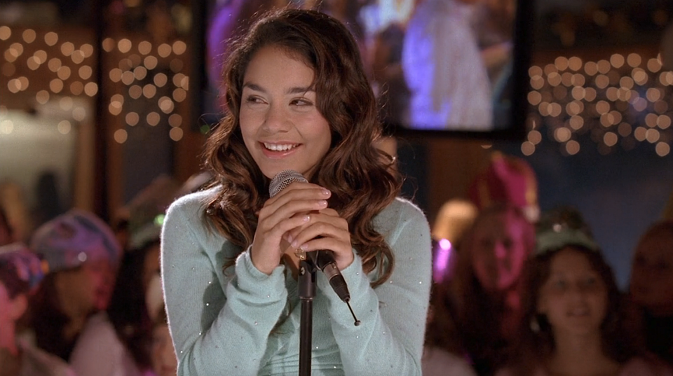 Gabriella standing at a mic