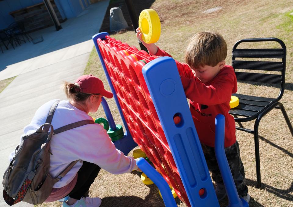 Heather Rhodes and her son Ford play with some of the lawn toys on March 14, 2023, at The Venue, a collection of restaurants, a bar, and entertainment venue on Watermelon Road in Tuscaloosa.
