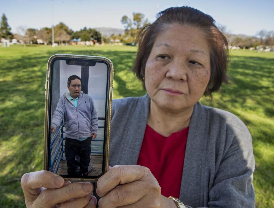 Mary Cabanete holds up a photograph of her son, Jude Cabanete.