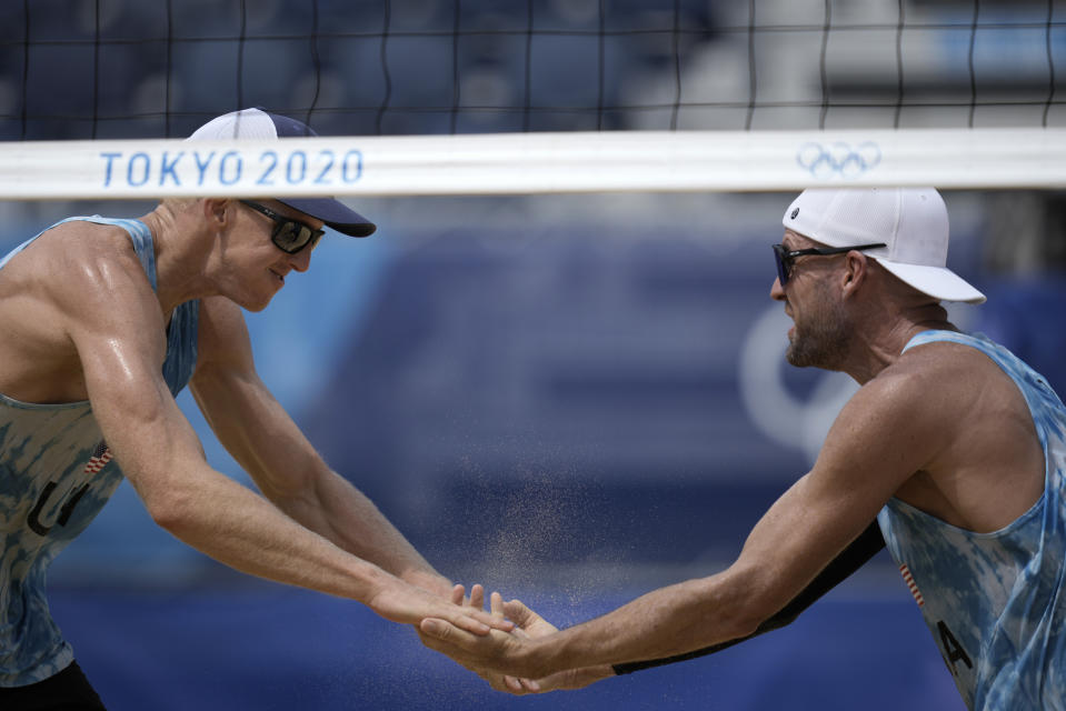 Tri Bourne, left, of the United States, celebrates with teammate Jacob Gibb, after winning a men's beach volleyball match against Switzerland at the 2020 Summer Olympics, Wednesday, July 28, 2021, in Tokyo, Japan. (AP Photo/Felipe Dana)