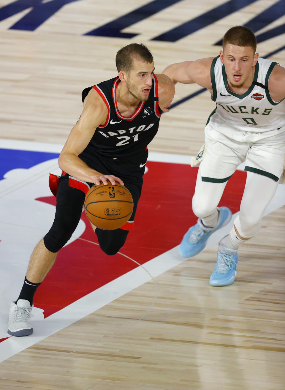 Toronto Raptors' Matt Thomas moves the ball as Milwaukee Bucks' Donte DiVincenzo defends during the fourth quarter of an NBA basketball game Monday, Aug. 10, 2020, in Lake Buena Vista, Fla. (Mike Ehrmann/Pool Photo via AP)