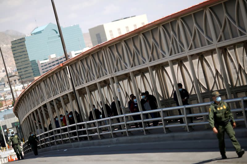 FILE PHOTO: Migrants expelled from U.S. and sent back to Mexico walk across border bridge in Ciudad Juarez