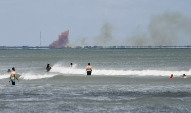 A cloud of orange smoke rises over Cape Canaveral