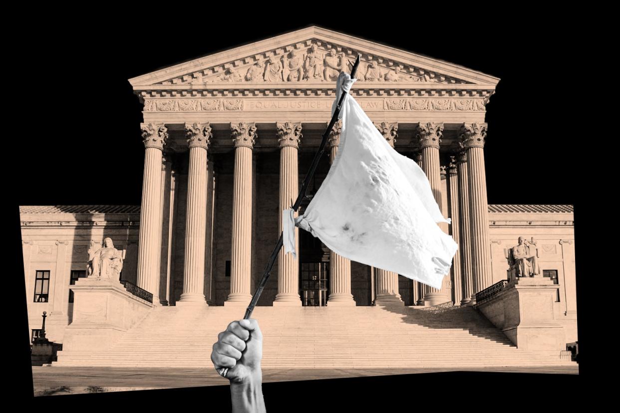 A white flag being waved in front of the Supreme Court.