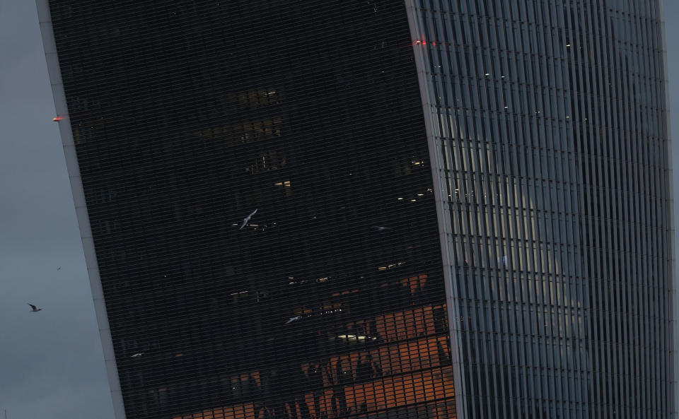 The sunset is reflected in the windows of 20 Fenchurch Street, a commercial skyscraper that takes its name from its address on Fenchurch Street, in the historic City of London financial district Saturday, March 6, 2021. It has been nicknamed "The Walkie-Talkie" because of its distinctive shape. (AP Photo/Alastair Grant)