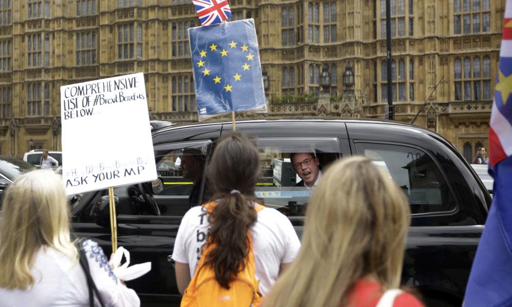 A man in a passing taxi shouts his disagreement at anti-Brexit protesters near the Houses of Parliament in London.