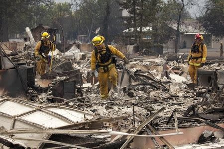 Firefighters search for victims in the rubble of a home burnt by the Valley Fire in Middletown, California, September 14, 2015. REUTERS/David Ryder