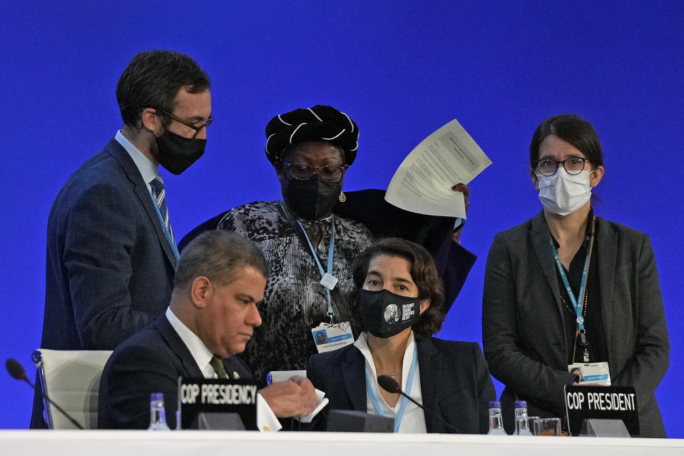 Alok Sharma President of the COP26 summit, front left, talks to advisors before speaking at the COP26 U.N. Climate Summit in Glasgow, Scotland, Thursday, Nov. 11, 2021. (AP Photo/Alastair Grant)