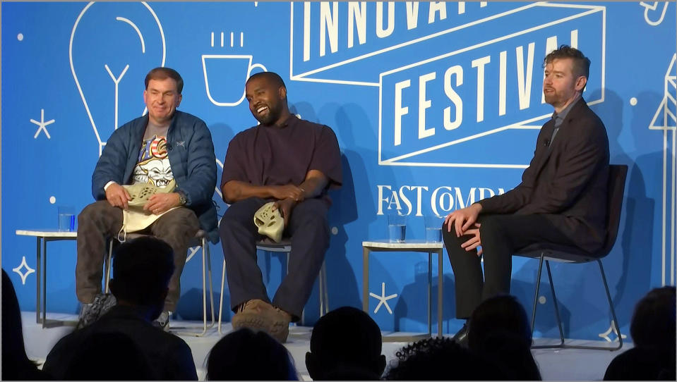 This image taken from video shows Kanye West, right, with Steven Smith, lead designer at Yeezy as Fast Company senior writer Mark Wilson, right, looks on during a discussion on fashion and design at the Fast Company Innovation Festival in New York on Thursday, Nov. 7, 2019. (AP Photo/David Martin)