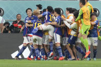 Japan players celebrate after Japan's Ritsu Doan scored his side's opening goal during the World Cup group E soccer match between Germany and Japan, at the Khalifa International Stadium in Doha, Qatar, Wednesday, Nov. 23, 2022. (AP Photo/Eugene Hoshiko)