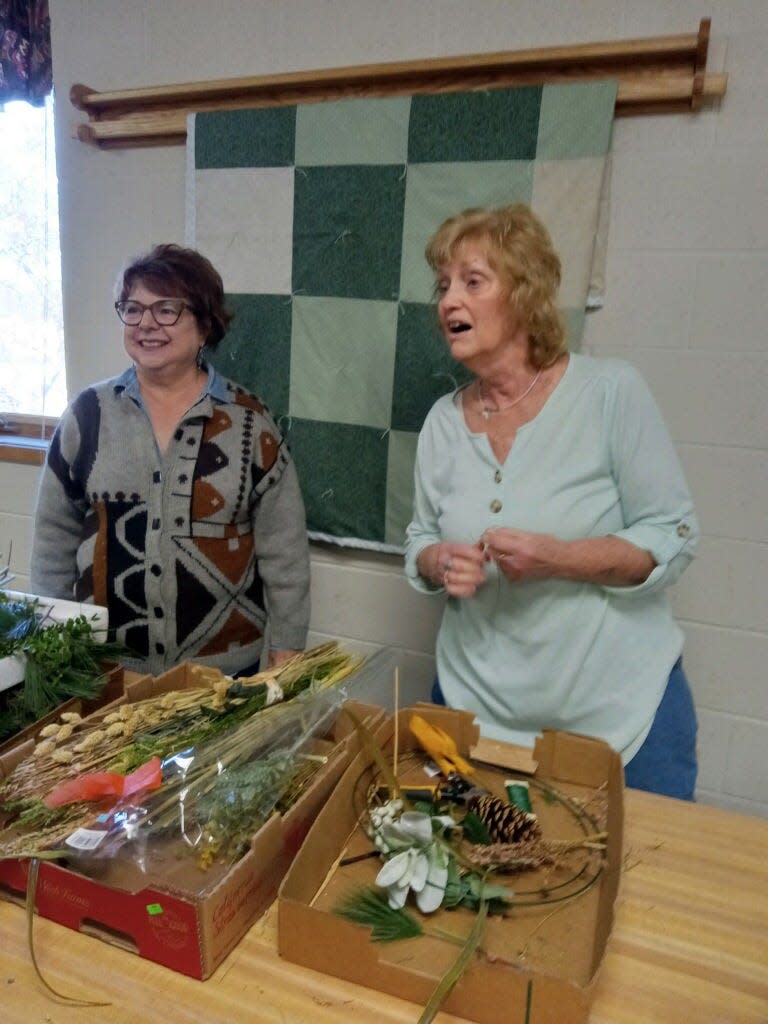 Peggy Stover, left, Art of Gardening member, joins Karen Pruner following her wreath presentation.
