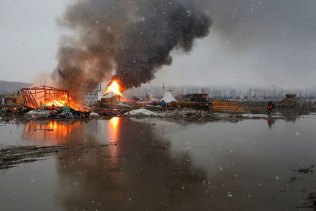 Buildings burn after being set alight by protesters preparing to evacuate the main opposition camp against the Dakota Access oil pipeline near Cannon Ball, North Dakota, U.S., February 22, 2017. REUTERS/Terray Sylvester