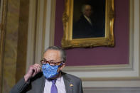 Senate Minority Leader Sen. Chuck Schumer of N.Y., takes off his mask as he arrives to speak to reporters on Capitol Hill in Washington, Wednesday, Dec. 30, 2020, before his meeting with Transportation Secretary-designate Pete Buttigieg. (AP Photo/Susan Walsh)