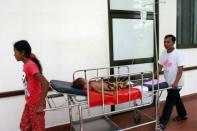 A woman pulls a child on a gurney at Kantha Bopha children's hospital in Phnom Penh. It's not bird flu or SARS, and nor does it appear to be contagious, but little more is known about a mysterious disease that has killed dozens of Cambodian children, some within 24 hours of being hospitalised