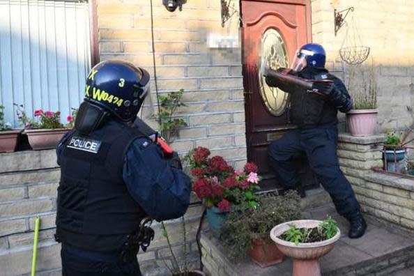 Police officers raid a house after about 10 per cent of the country's county lines drug networks were shut down: NPCC/PA