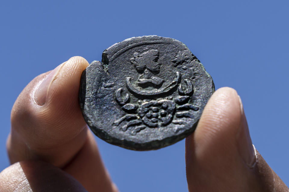 A rare, nearly 1,850-year-old bronze coin discovered off the Israeli coastal city of Haifa is on display at Israel's Antiquities Authority office in Jerusalem, Tuesday, July 26, 2022. The coin bears the image of the zodiac sign Cancer behind a depiction of the moon goddess Luna. Experts said Monday the coin was minted in Alexandria, Egypt, under the rule of the Roman Emperor Antoninus Pius in the second century. The antiquities authority says it is the first time such a coin has been found off the Israeli coast. (AP Photo/Tsafrir Abayov)