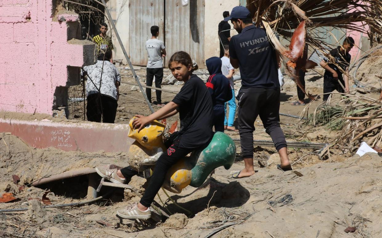 People inspect damage and recover items from their homes following Israeli air strikes on April 04