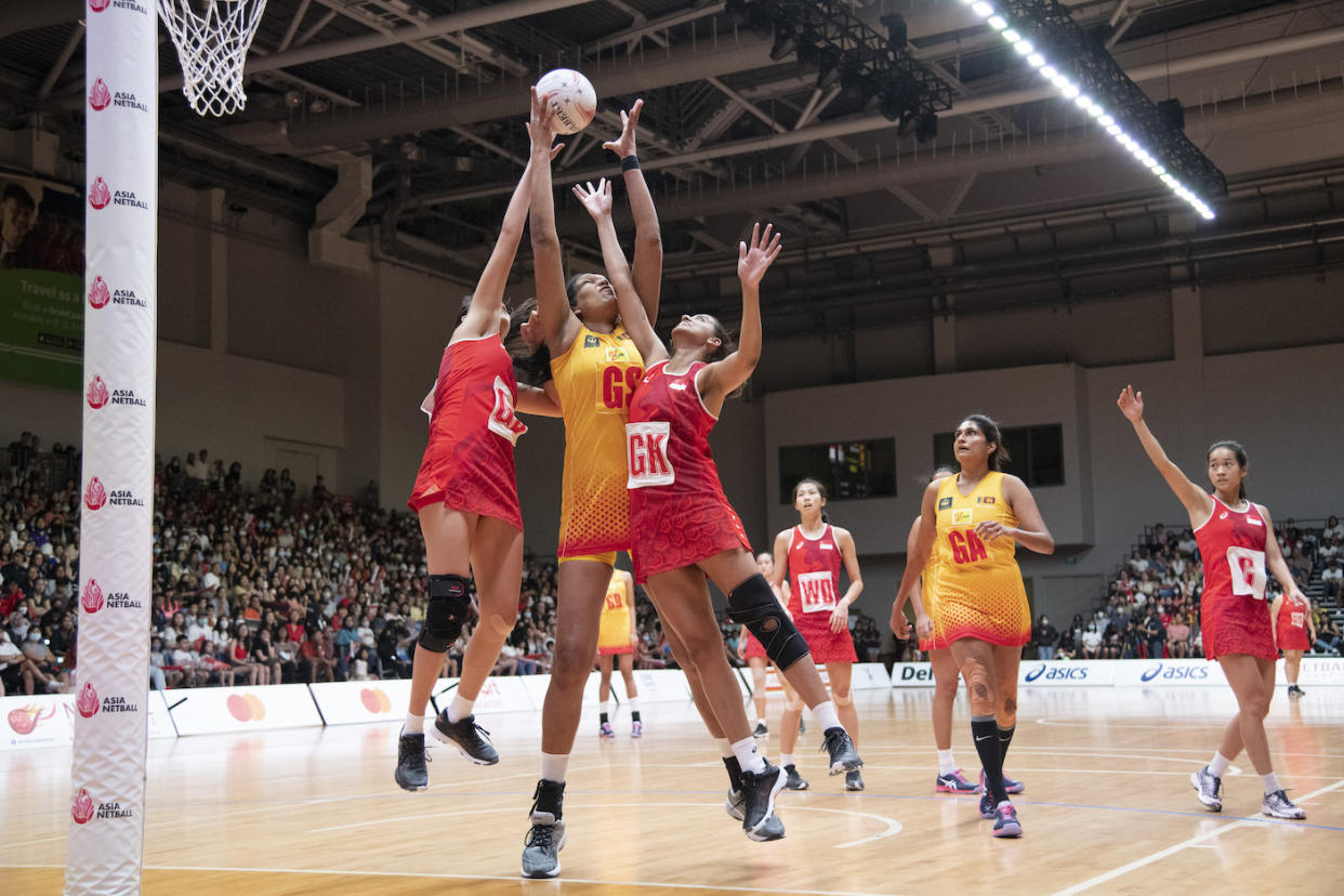 Singapore's Jamie Lim (left) and Sindhu Nair (third from left) battle for the ball with Sri Lanka's Tharjini Sivalingam in the Asian Netball Championships final at the OCBC Arena. (PHOTO: Netball Singapore)