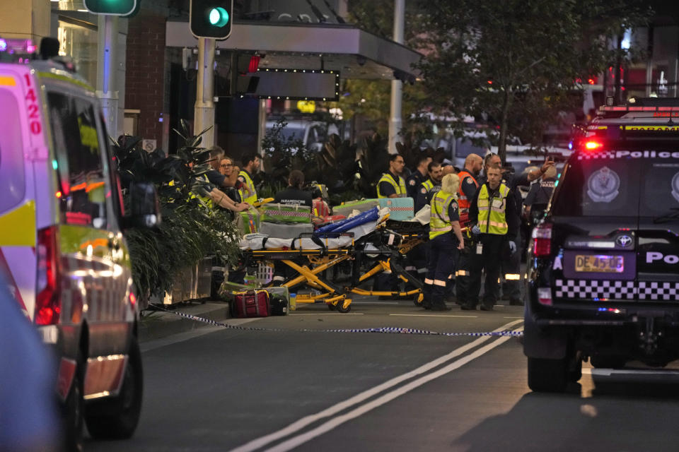 Emergency officers stand by with stretchers outside Westfield Shopping Centre where multiple people were stabbed in Sydney, Saturday, April 13, 2024. A man stabbed six people to death at the busy Sydney shopping center Saturday before he was fatally shot, police said. (AP Photo/Rick Rycroft)
