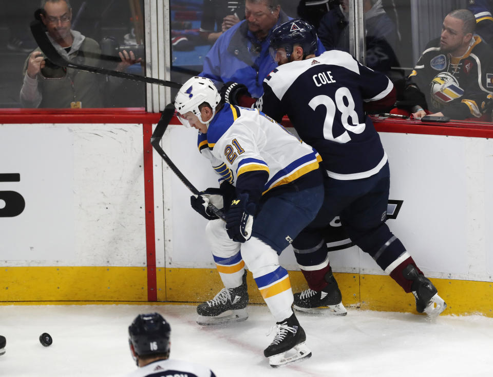 St. Louis Blues center Tyler Bozak, left, fights for control of the puck with Colorado Avalanche defenseman Ian Cole in the first period of an NHL hockey game Saturday, Jan. 18, 2020, in Denver. (AP Photo/David Zalubowski)