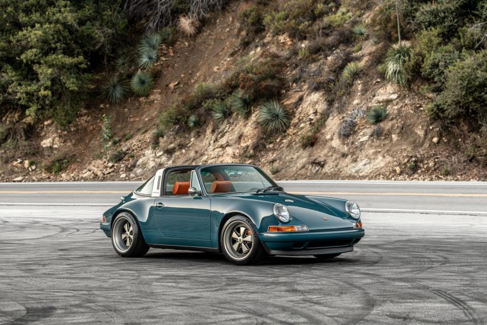 a blue 911 targa parked on a mountain road