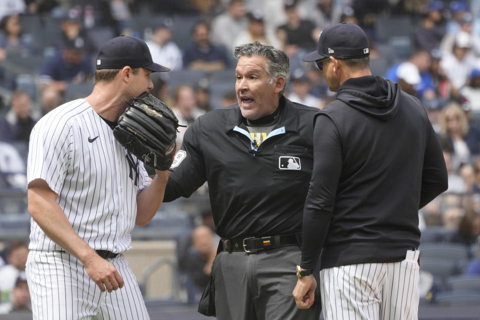 New York Yankees pitcher Gerrit Cole, left, and manager Aaron Boone, talk to umpire Manny Gonzalez, center in the fifth inning of a baseball game against the Toronto Blue Jays, Saturday, April 22, 2023, in New York. (AP Photo/Mary Altaffer)