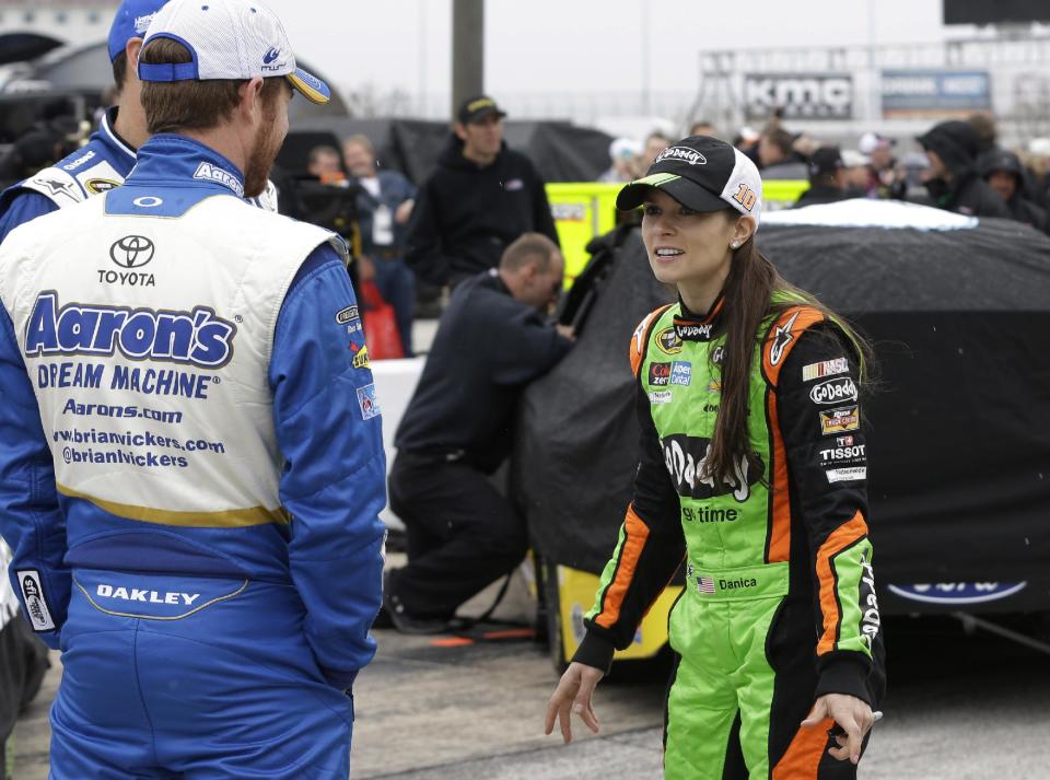 Danica Patrick, right, talks with fellow drivers before qualifications for the NASCAR Sprint Cup Series auto race at Texas Motor Speedway in Fort Worth, Texas, Saturday, April 5, 2014. (AP Photo/LM Otero)