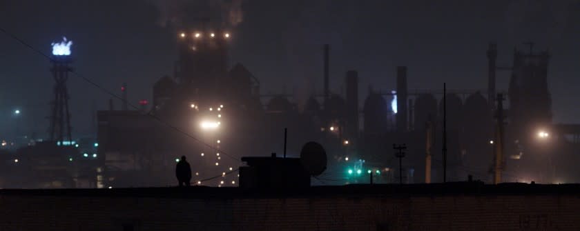 Andriy Rymaruk silhouetted at night against an industrial backdrop in the movie "Atlantis."