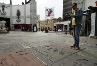 A man takes a picture of the hand and footprints of actor Tom Hanks in the forecourt of the TCL Chinese Theatre, Thursday, March 12, 2020, in the Hollywood section of Los Angeles. Hanks and his wife, actress-singer Rita Wilson, have tested positive for the coronavirus, the actor said in a statement Wednesday. For most people, the new coronavirus causes only mild or moderate symptoms. For some it can cause more severe illness. (AP Photo/Chris Pizzello)