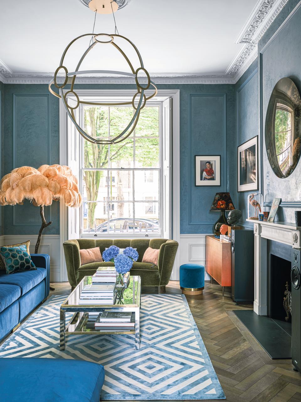 A living room painted blue with a large sash window