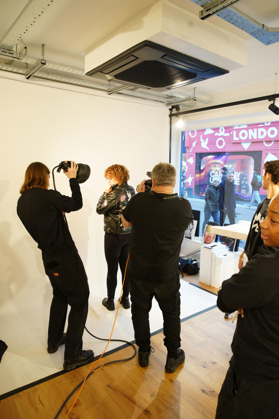 Portrait and fashion photographer Rankin taking photographs at RankinLive London Carnaby Street, November 2023